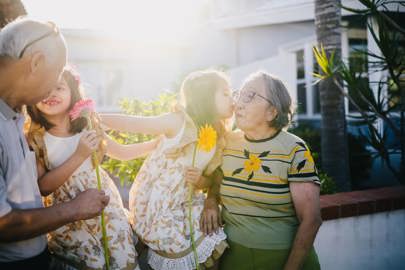 Grandparents and grandchildren with flowers and kisses